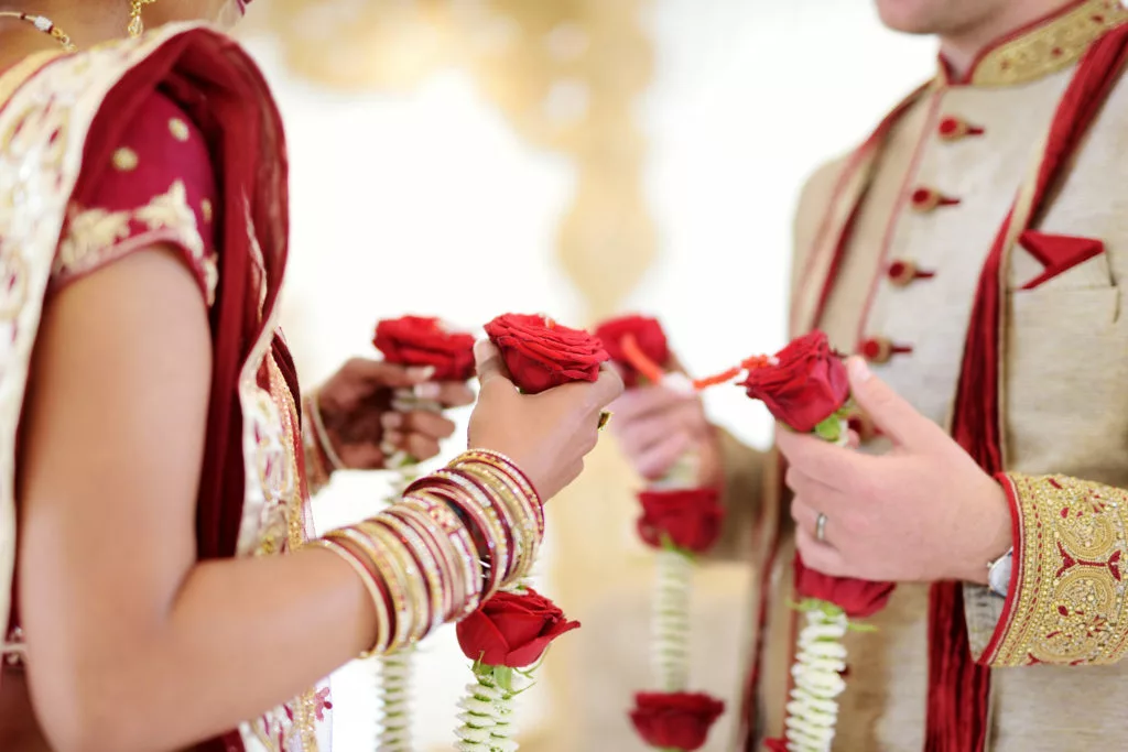 12 Pre-Booking Questions To Ask Your Wedding Photographer Wedding Photographer - Hindu Wedding - Couple With Roses
