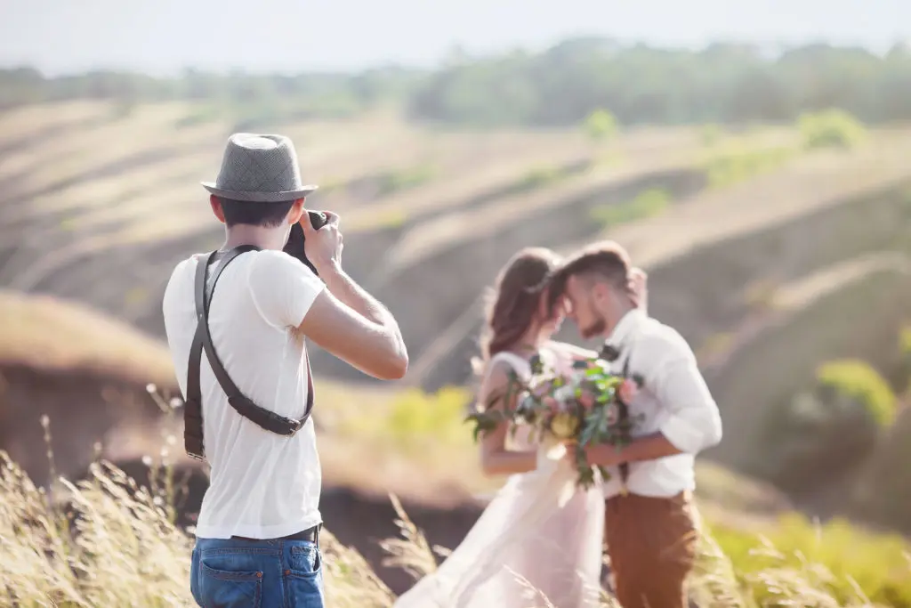 12 Pre-Booking Questions To Ask Your Wedding Photographer Wedding Photographer - Man Photographing Couple Outside