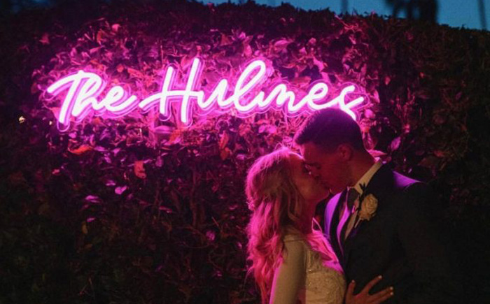 6 Things To Definitely Skip If You’re A Budget Bride Budget Bride - Skip Neon Signage - Bride And Groom Kissing Under Pink Custom Neon Sign