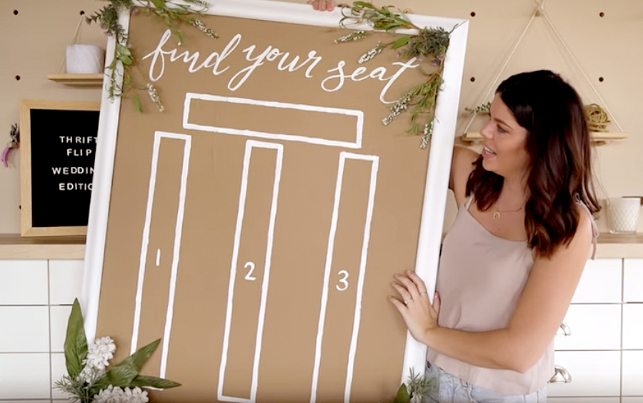 Wedding Hacks To Save You Money And Stress Wedding Hacks - Brunette Woman Holding Up Seating Chart