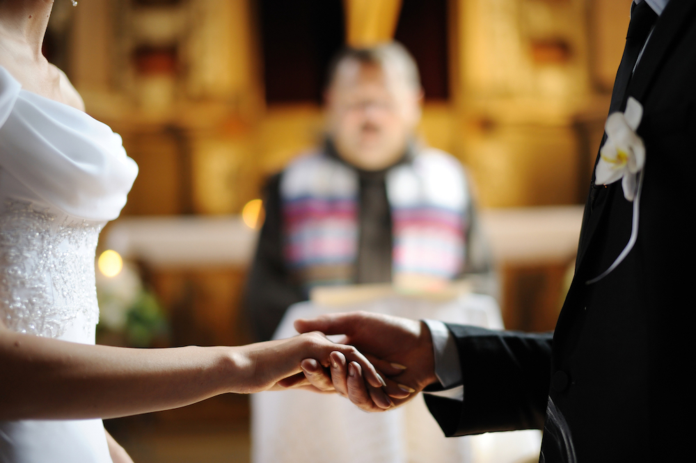 Bride And Groom Holding Hands At Church.