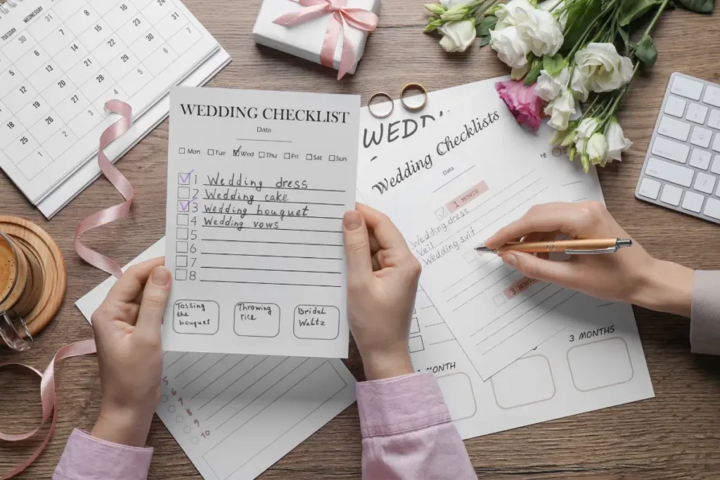 Wedding Planning Checklist: How to Plan a Wedding Step by Step Without Missing Anything Hands filling out a wedding planning checklist to track decisions and keep the planning process on schedule.