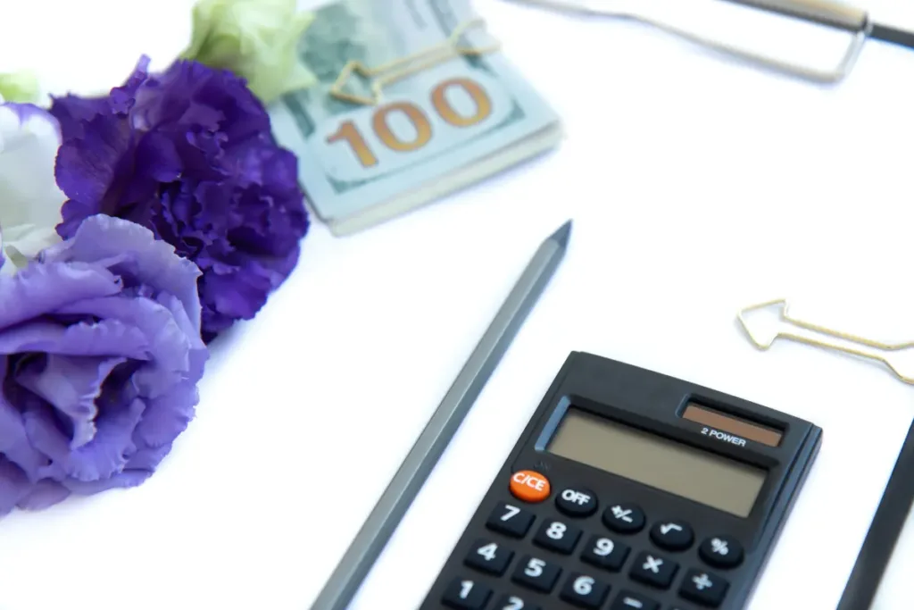 All-Inclusive Venues: What They Really Offer and Why Couples Choose Them Flat lay of calculator, cash, and flowers representing event budgeting and planning decisions